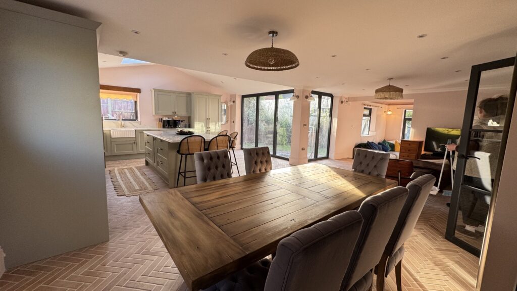 Elegant dining area in a rear ground floor extension with whole house refurbishment, featuring a large dining table and modern lighting.